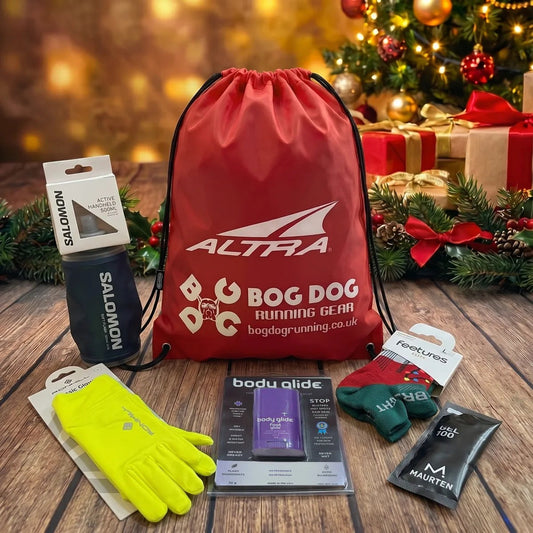 Silver runner’s Christmas gift set: Salomon Active Handheld flask, Ronhill Classic Gloves, Feetures Elite Christmas socks, Body Glide Foot Glide and a Maurten Gel 100 with a red Bog Dog and Altra drawstring bag